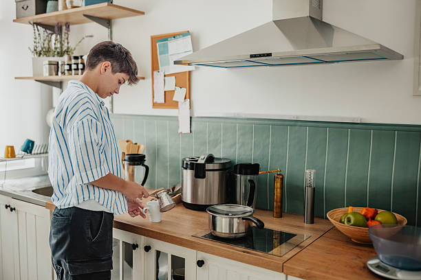 istock Young woman preparing coffee in her stylish kitchen during a weekend leisure activity 2238054929