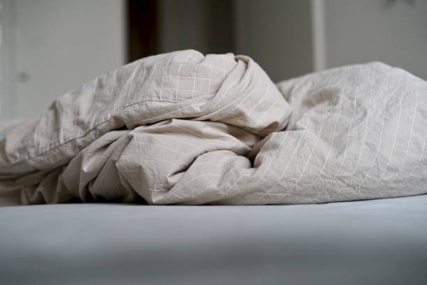 istock A cozy bed topped with a multitude of sheets and fluffy pillows 2238055808