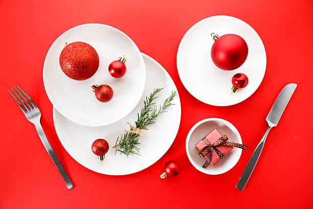 istock White dishes with Christmas ornaments on red background. 2238058226