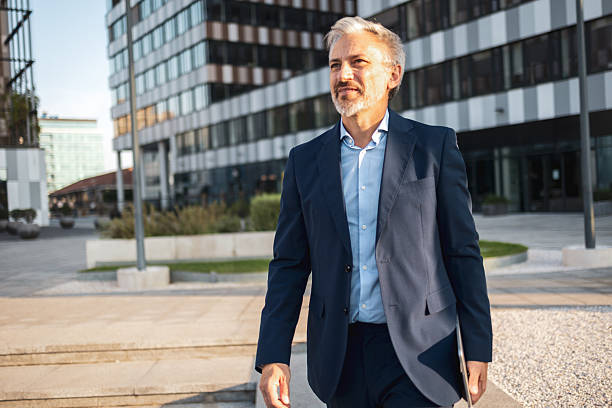 istock Confident businessman walking in modern city with tablet 2238059016