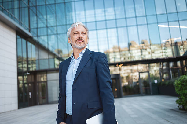 istock Mature businessman outdoors looking confident holding laptop 2238059021