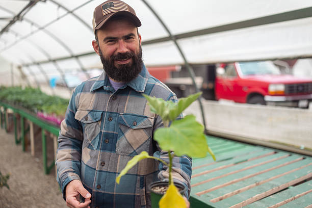 istock Bearded Man in Greenhouse Holding Seedling 2238061151