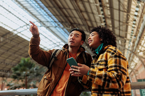 istock Tourists using smart phone and pointing inside station building 2238061445