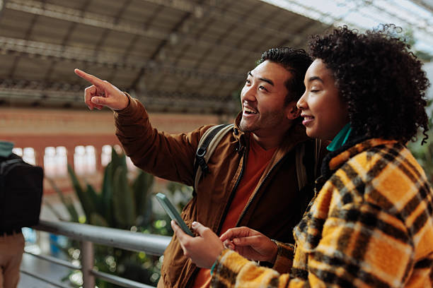 istock Tourists using smart phone and pointing at something interesting in train station 2238061463