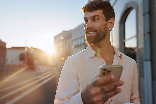istock Handsome young manager using smartphone at sunset in the city 2238062502