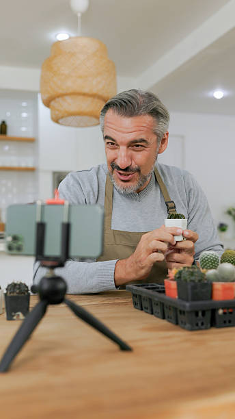 istock Man demonstrates plant care techniques while filming a tutorial in a cozy indoor garden setting 2238065719