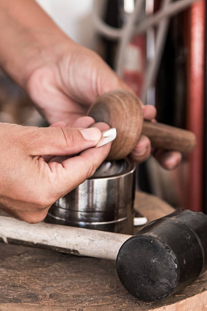 istock jeweler shaping a piece of silver with her hands 2238070774