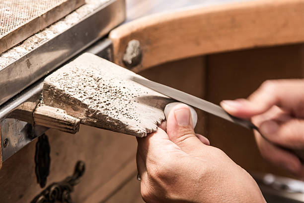 Jewelry artisan filing a piece of silver by hand