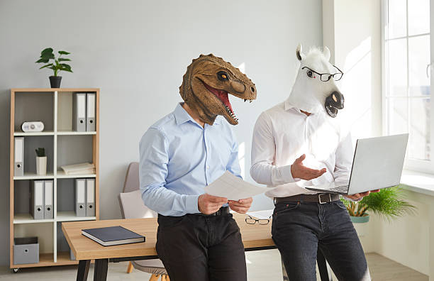 istock Two funny business people in animal masks using laptop computer at work in office 2238071302