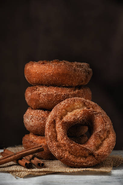 istock A stack of Fresh made Apple cider Donuts with one leaning on the stack against a mottled dark brown background with copy space. 2238076119