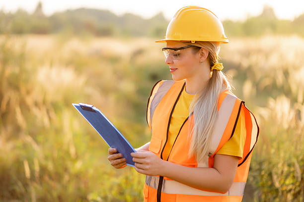 istock Female worker inspecting outdoors with clipboard and safety gear during sunset. 2238078376