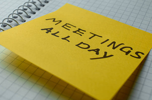 Bright yellow sticky note details a full day of meetings
