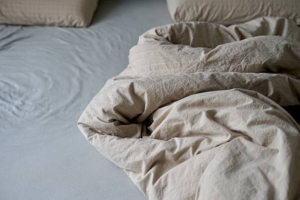 istock There is a bed that has a blanket and several pillows positioned on it bedsheet messy unmade do bed routine housekeeping 2238082583