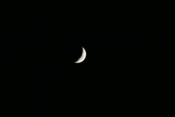 istock A crescent moon illuminated against a dark night sky. 2238082974