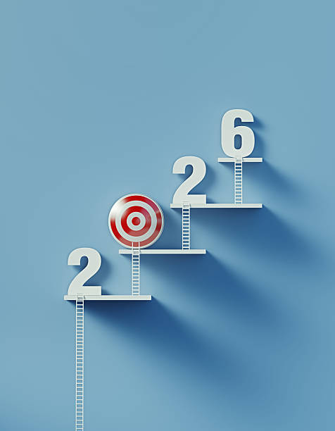 2026 Resolutions Concept - White Ladders Leans Over A Bull's Eye Target and Writes 2026 on Blue Wall