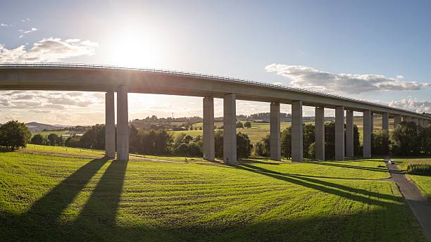 istock Scenic bridge over green landscape with sun. 2238092135