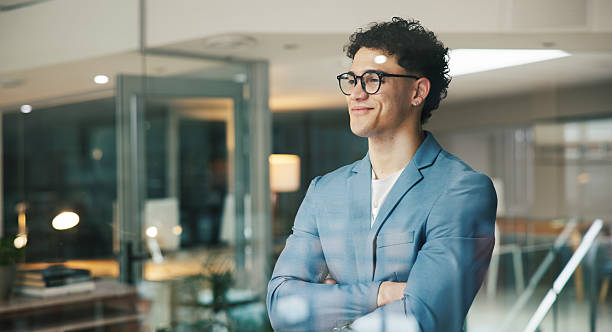 Thinking, window and business man in office, proud reflection and vision for company growth. Ideas, ambition and manager with smile for corporate development, planning and dream for future success