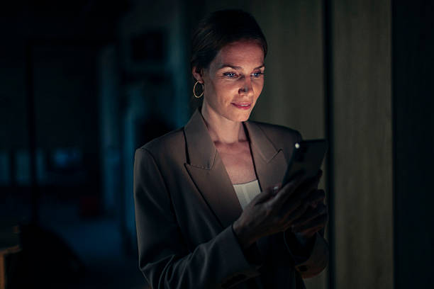 istock Professional Woman Using a Smartphone in a Dimly Lit Environment 2238093299