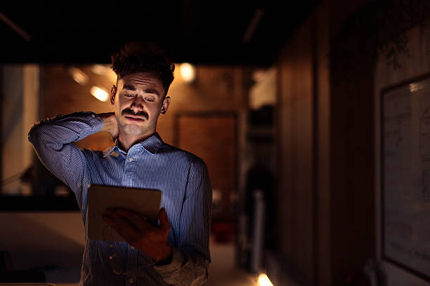 istock Professional Man Reading Digital Tablet in Dimly Lit Office Environment 2238093342