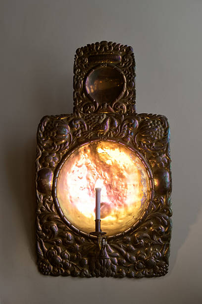 Intricate decorative wall sconce featuring a candleholder and colorful glass panel from a historical era