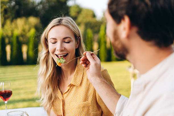 istock Romantic couple sharing salad during outdoor garden dinning 2238096412