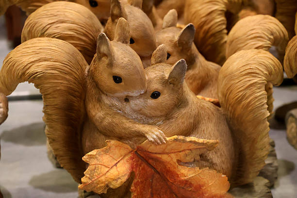 Figurines of Two cuddling squirrels with a big leaf