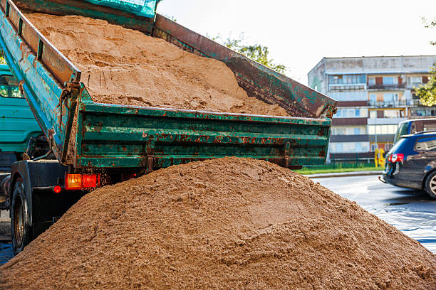 istock Green Dump Truck Unloading Sand Near Residential Building 2238105943