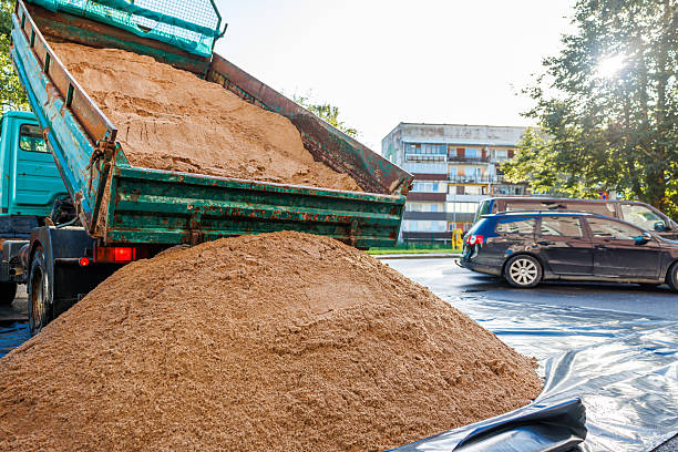 istock Green Dump Truck Unloading Sand Near Residential Building 2238105944