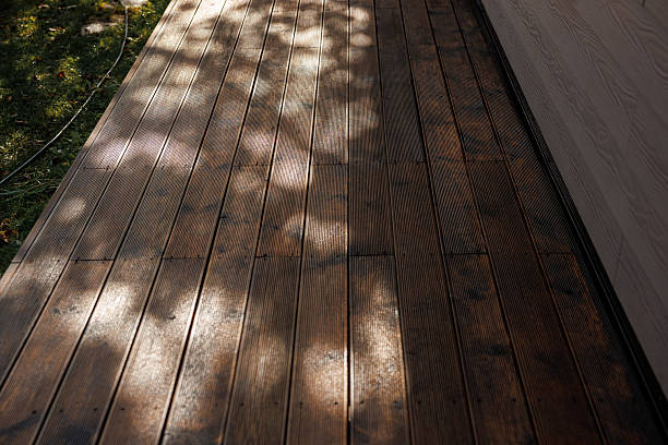 Weathered Wooden Deck with Dappled Light and Grassy Area