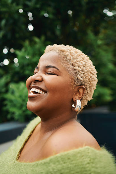 istock Joyful African Woman Smiling Outdoors in Natural Light with Greenery in Background 2238106952