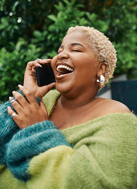 istock Joyful Woman Laughing on a Phone Call in an Outdoor Setting 2238106975