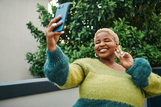 istock Smiling Woman Posing for a Selfie Against Vibrant Greenery 2238106984