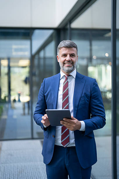 istock Smiling businessman using digital tablet in modern office building 2238108196