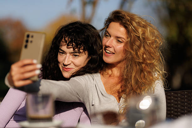 istock Friends enjoying a sunny day outdoors while taking a selfie together at a cafe with a scenic view in the background 2238108749