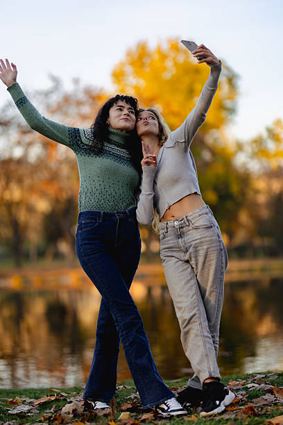 istock Two friends capture a joyful moment while taking selfies together in a scenic park during a sunny autumn afternoon 2238108812