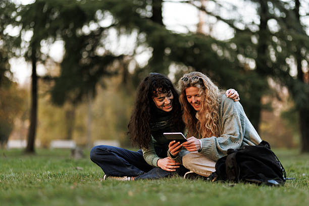 istock Two friends enjoying a sunny afternoon in the park while browsing a tablet and sharing laughs 2238108825