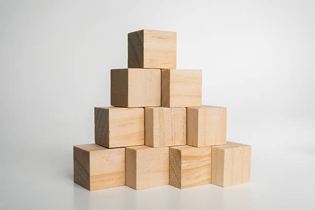 istock Wooden cubes stacked in pyramid formation on white background symbolizing growth, balance, stability 2238109458