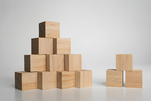 istock Wooden cubes arranged in pyramid and small stack on white background symbolizing growth and teamwork 2238109459
