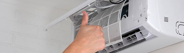 istock Maintenance Complete. Technician Installing Clean Air Filter in Air Conditioner 2238111270