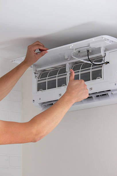 istock Maintenance Complete. Technician Installing Clean Air Filter in Air Conditioner 2238111275