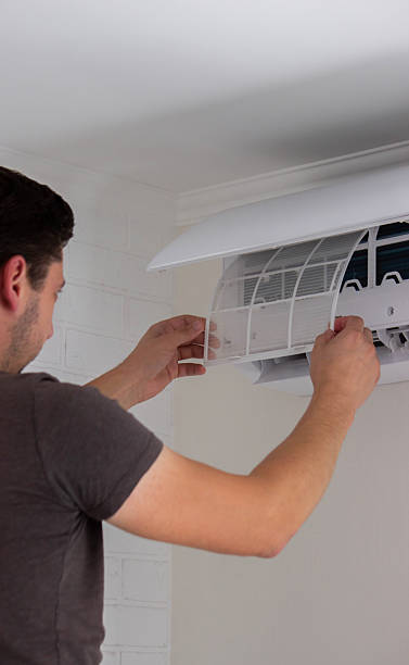 istock Maintenance Complete. Technician Installing Clean Air Filter in Air Conditioner 2238111278