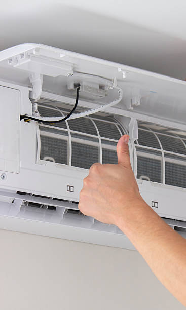 istock Maintenance Complete. Technician Installing Clean Air Filter in Air Conditioner 2238111279