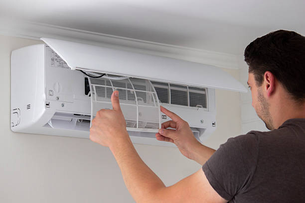 istock Maintenance Complete. Technician Installing Clean Air Filter in Air Conditioner 2238111281