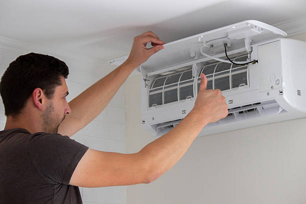 istock Maintenance Complete. Technician Installing Clean Air Filter in Air Conditioner 2238111283