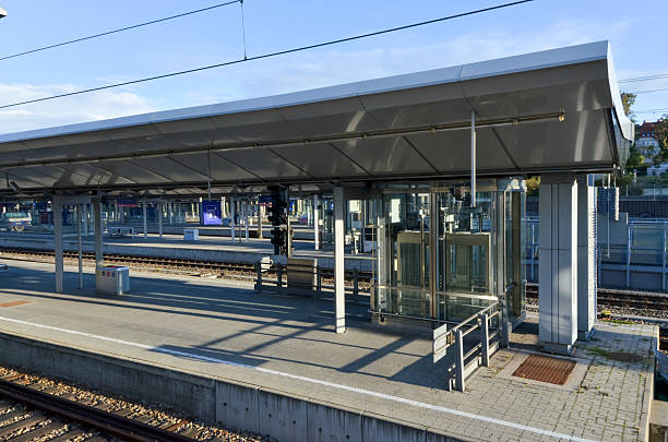 istock Modern train station platform with glass elevator and shelter roof. 2238112010