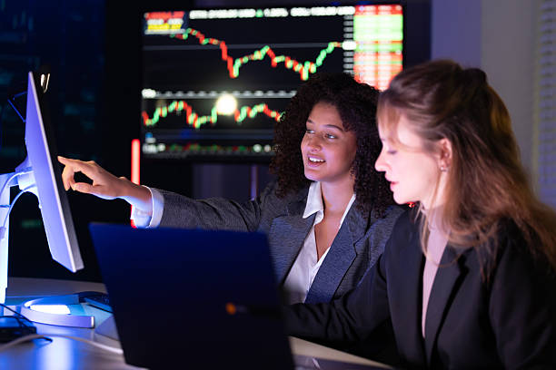 istock Colleagues discuss stock market trends in a modern office setting during evening hours 2238114049