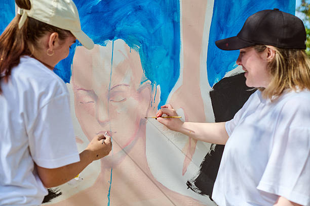 istock Two young women collaborating on large wall art 2238114547
