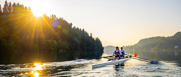 istock Two Women Rowing Double Scull on Serene Lake at Sunset 2238115849