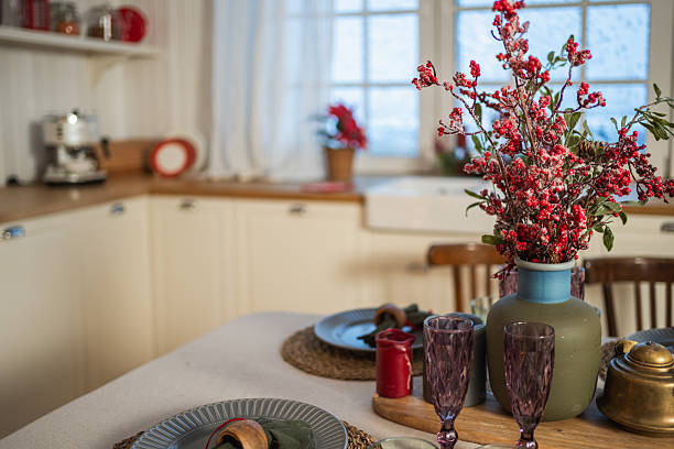 Classical Christmas decorated interior kitchen. Modern classic style interior design apartment dining with red frosty branches bouquet ornament Christmas decorations. Christmas eve at home
