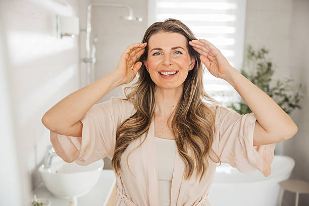istock Mature woman applying moisturizer on face 2238118050